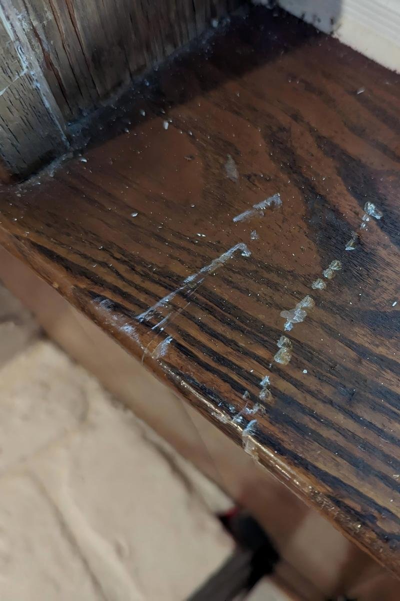 Cracked wooden interior window sill with failing joints — before replacement